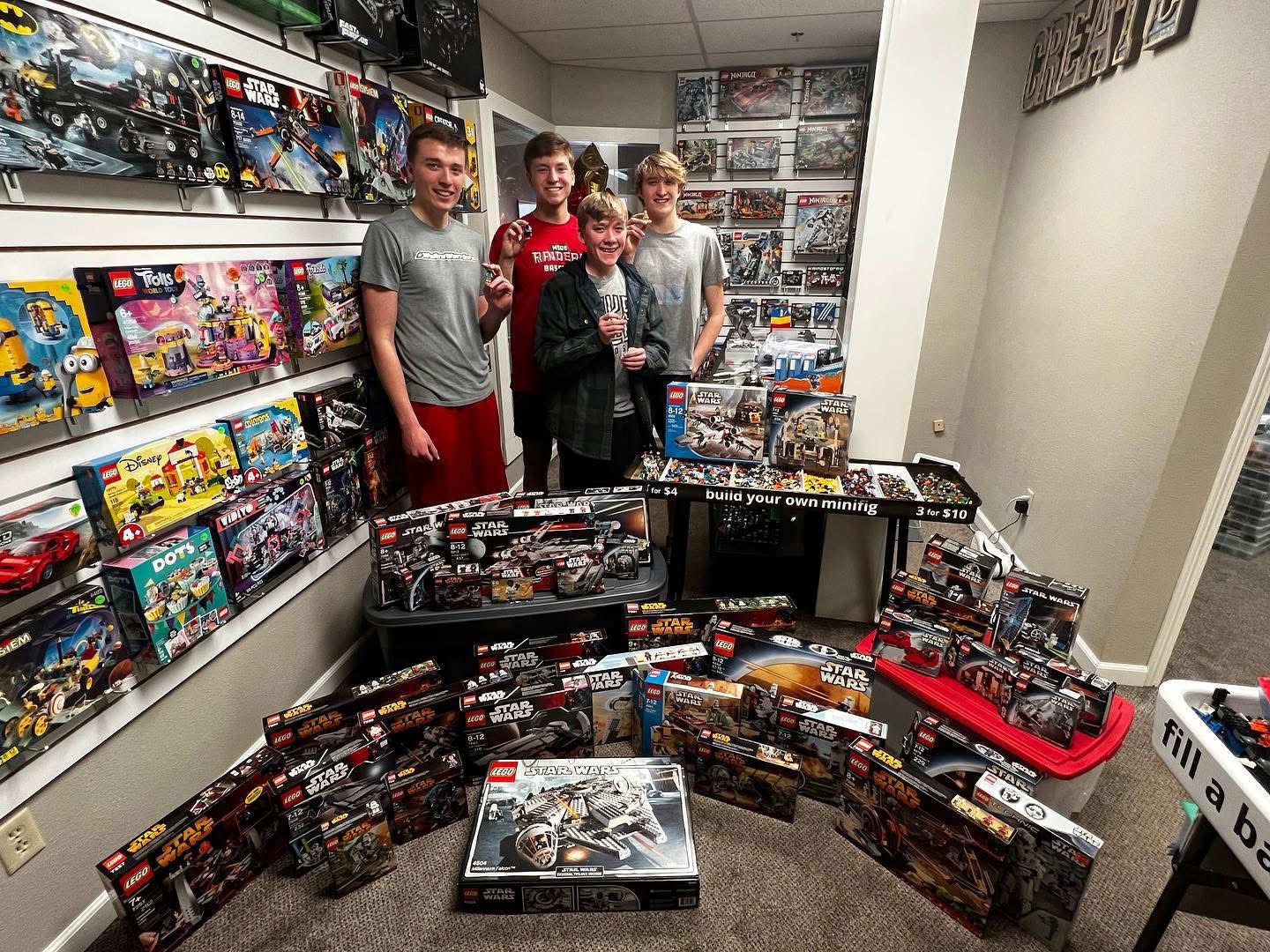 Zach, Isaiah, and visitors surrounded by LEGO sets in the original Wapi Bricks store